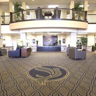 A spacious hotel lobby featuring a grand entrance and modern furnishings.
