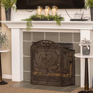 Elegant living room fireplace with decorative candles and plants on the mantel.
