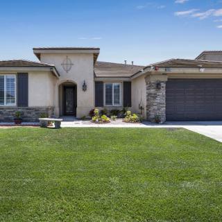A modern single-story house with a well-maintained lawn and a two-car garage.