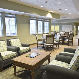 A cozy and well-lit living area with comfortable seating and a central table.