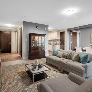 A modern living room with a comfortable sofa, coffee table, and an adjacent dining area.