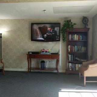 A cozy living room with a television, bookshelf, and comfortable seating.