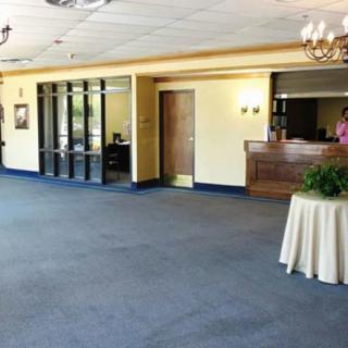 A spacious lobby with a reception desk and carpeted flooring.