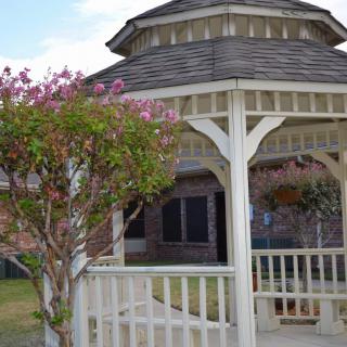 A charming gazebo surrounded by blooming flowers in a garden setting.