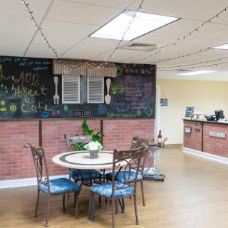 A cozy cafe interior with a chalkboard menu and seating area.