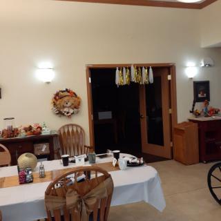 A cozy dining room with a decorated table and chairs, featuring warm interior designs.