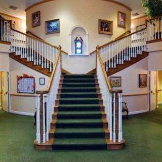 Symmetrical staircase with carpeted steps and artwork on the walls.