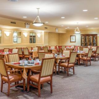 A spacious and elegantly decorated dining area with neatly arranged tables and chairs.