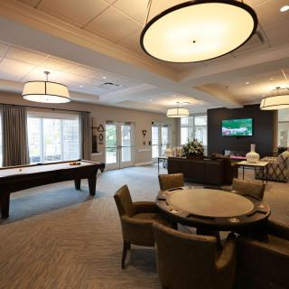 Spacious game room with a pool table, seating area, and a television.