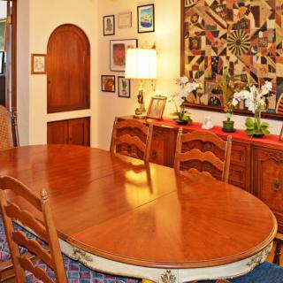 A cozy dining room with a wooden table and chairs, adorned with wall art and decorative pieces.