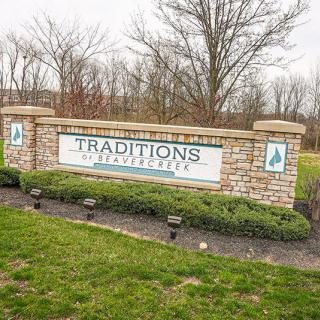 Entrance sign to the Traditions community with landscaping and brick design.