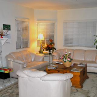 A cozy living room with a large sofa, coffee table, and warm lighting.