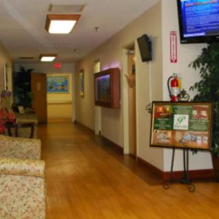 A hospital hallway with seating and a television.