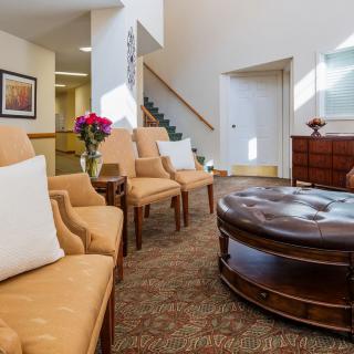A cozy living room with comfortable chairs and a round coffee table.