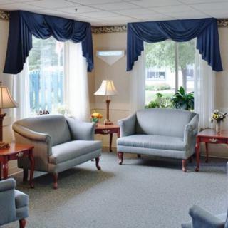 A cozy living room with matching furniture and blue curtains.