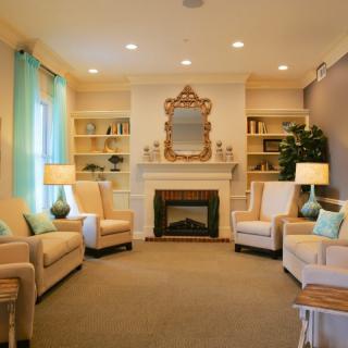 A cozy living room with elegant furniture and a central fireplace.