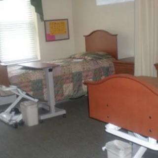 A hospital room with a bed and medical furniture.