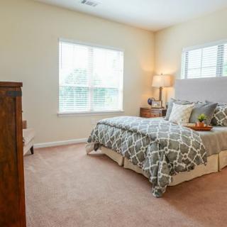 A cozy bedroom with a large bed, stylish bedding, and warm lighting.