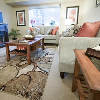 A cozy living room with a comfortable sofa, wooden coffee table, and decorative rug.