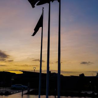 A beautiful sunset with flags silhouetted against the colorful sky.