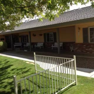A charming house with a well-maintained front yard and porch seating.