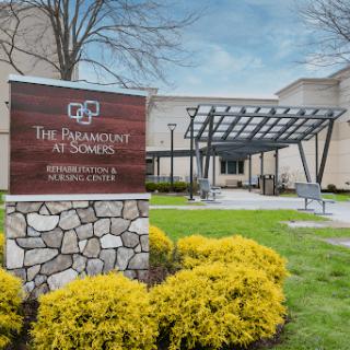 The entrance to The Paramount at Somers, showcasing its welcoming exterior and landscaped surroundings.