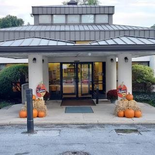 A welcoming entrance decorated with pumpkins and hay bales for the fall season.