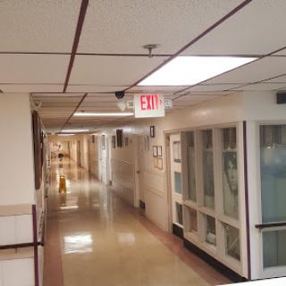 A view of a quiet hospital hallway with overhead lighting.