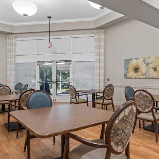 A cozy and well-lit dining area featuring tables and chairs, perfect for gatherings.