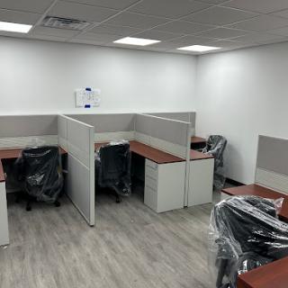 A newly furnished office space featuring multiple empty cubicles and desks.