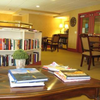 A cozy reading area with books and furniture in a library setting.