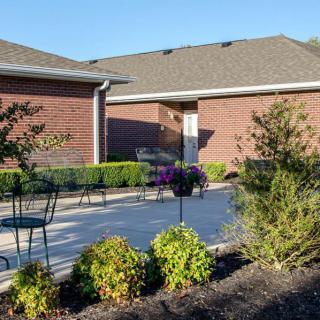A sunny patio area with outdoor furniture and surrounding greenery.
