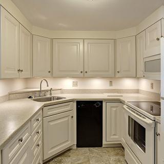 A modern kitchen with white cabinets and sleek appliances.