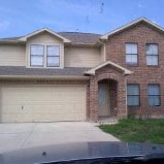 A two-story house with a brick facade and attached garage.