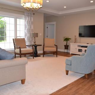 A cozy living room with comfortable seating, a large window, and a television.