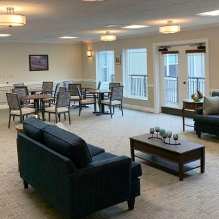 A spacious and well-lit living area with sofas, dining tables, and elegant interior decor.