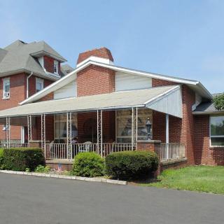 A suburban brick house with a large covered porch.