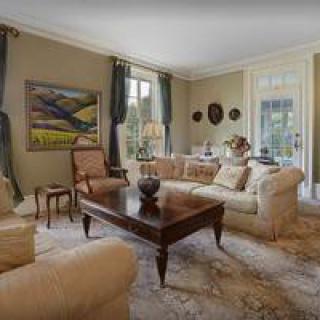 A classic style living room featuring elegant sofas, a central coffee table, and artwork on the walls.