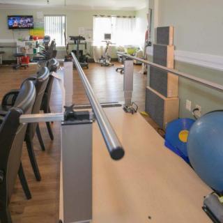 A rehabilitation center equipped with parallel bars and exercise equipment for physical therapy.