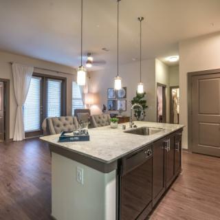 A modern open-concept kitchen with an island and pendant lighting.