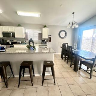 A spacious and inviting kitchen with a modern dining area perfect for family gatherings.
