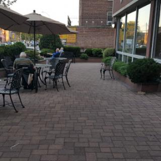 A cozy outdoor dining area with tables and umbrellas, perfect for an evening meal.