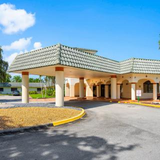 A sunny day view of a building entrance with a driveway.