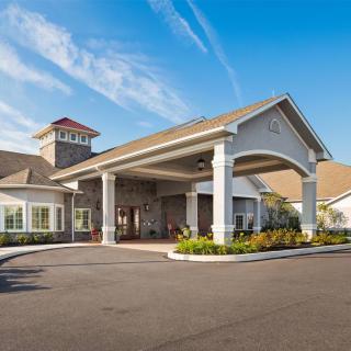 A modern building with a grand entrance under a clear blue sky.