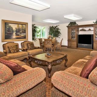 A cozy living room with traditional furniture, featuring a sofa set, coffee table, and entertainment center.