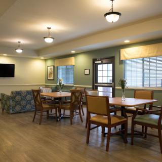 A cozy dining area designed for community gatherings, featuring ample seating and natural light.