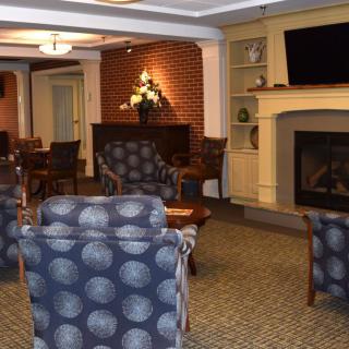A cozy living room with comfortable seating, a fireplace, and a television.