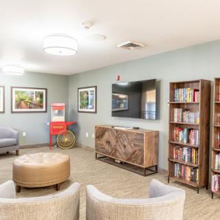 A cozy living room with bookshelves, a TV, and comfortable seating.