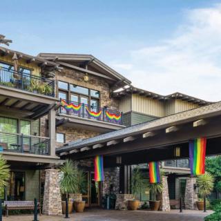 A modern building exterior adorned with rainbow flags during the daytime.