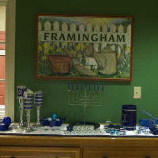 A display featuring a menorah and festive decorations beneath a 'Framingham' art piece on the wall.